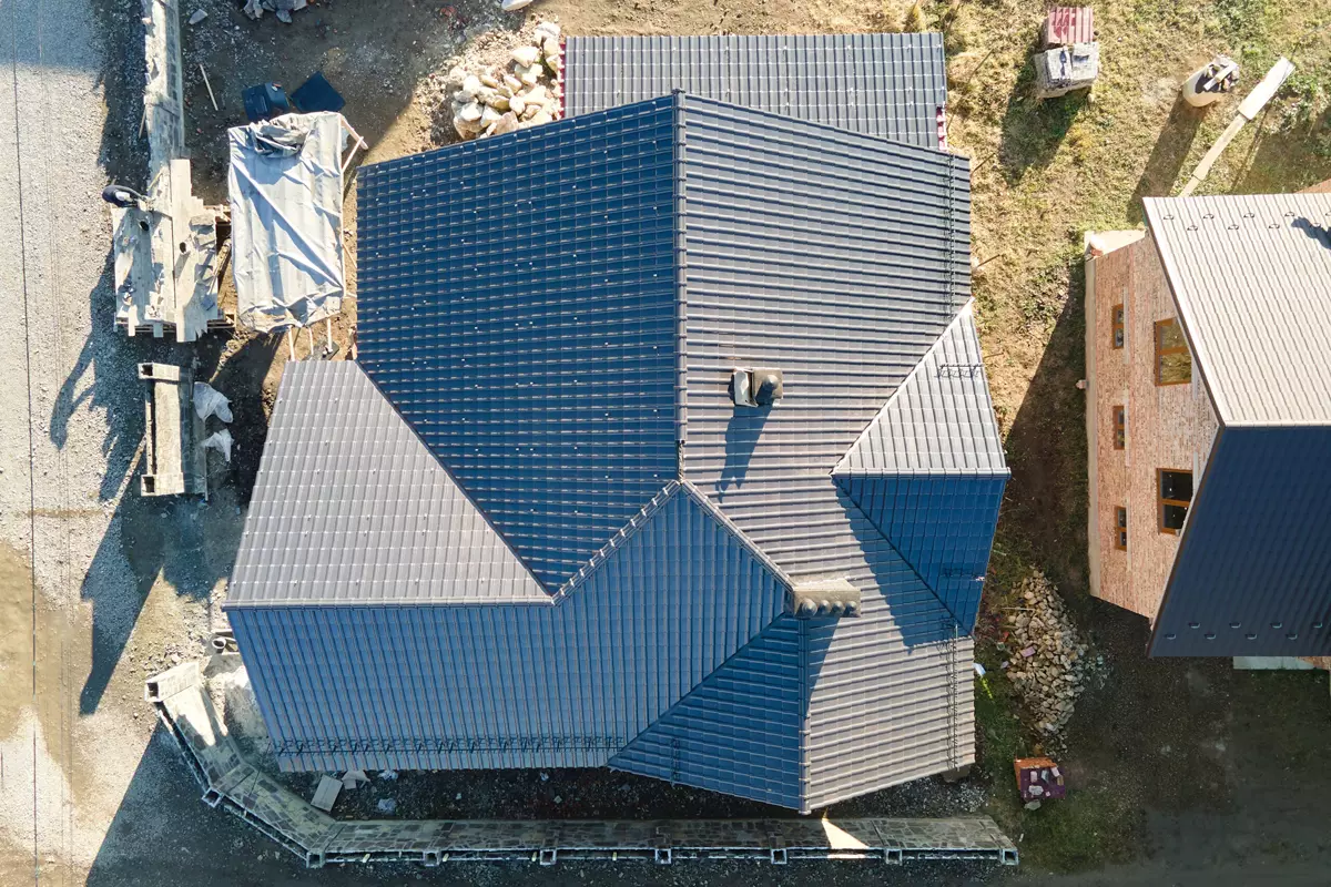 chimney-on-house-roof-top-covered-with-metallic-sh-2024-12-06-16-39-08-utc-scaled-1.webp